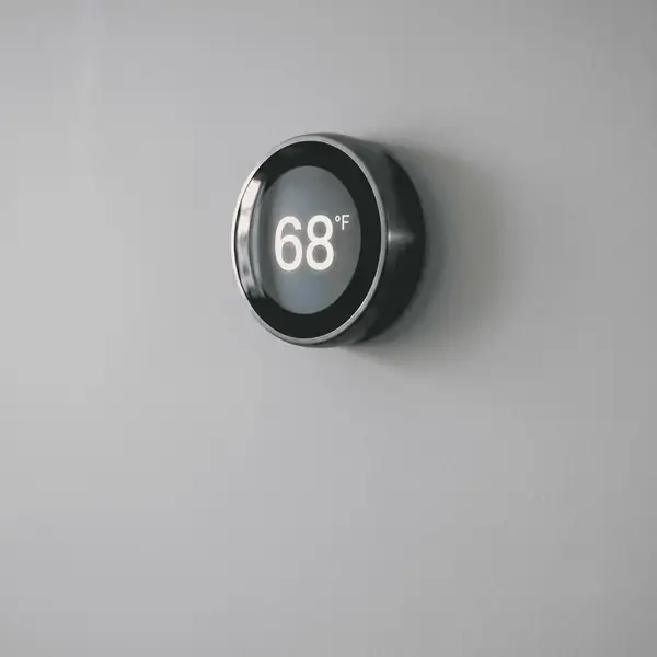 Smart thermostat being installed on a living room wall